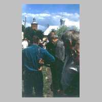 111-1076 Besucher vor der neuen orthodoxen Kapelle. Im Hintergrund der Turm der Ruine der evangelischen Pfarrkirche Wehlau.jpg